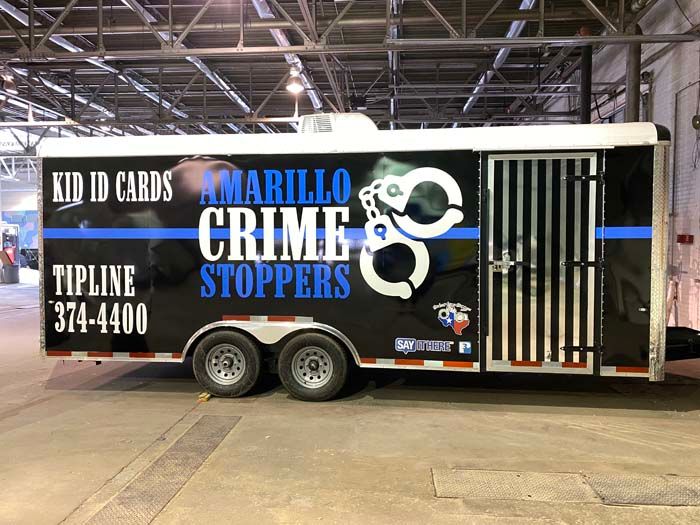 Black trailer for Amarillo Crime Stoppers, with text and handcuff logo.
