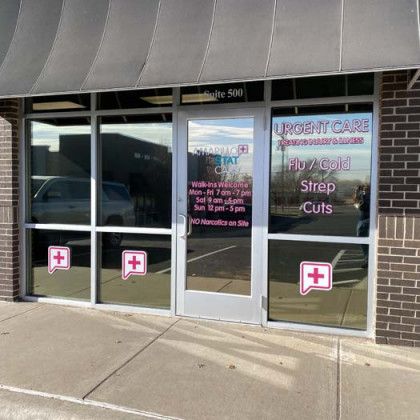 Exterior of an urgent care clinic with a glass door and window. Pink cross symbols and text: Flu/Cold, Cuts, and Strep.