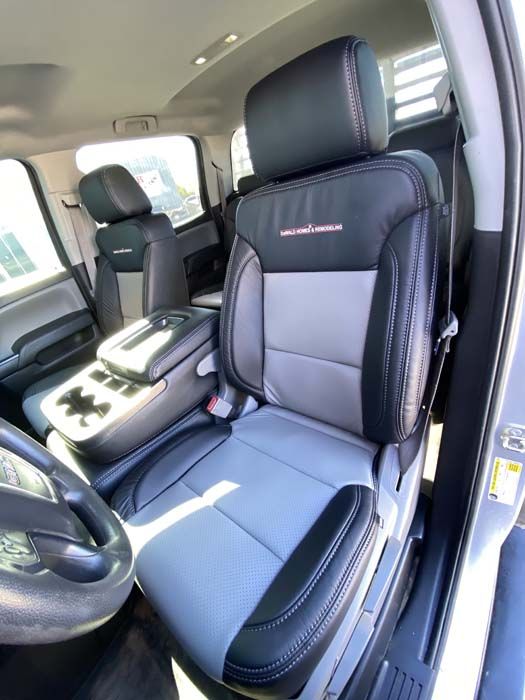 Gray and black leather truck seats with red stitching and logo, viewed from inside the cab.