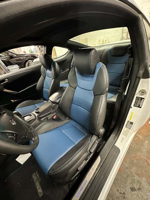 Interior of a blue and black car with leather seats.