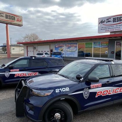 Two Camrun Police cars parked outside a building with a sign that says 