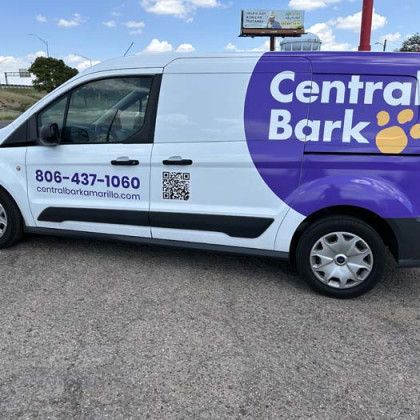 White and purple Central Bark service van parked on asphalt with phone number and QR code.