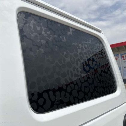 White vehicle window with dark spotted pattern.