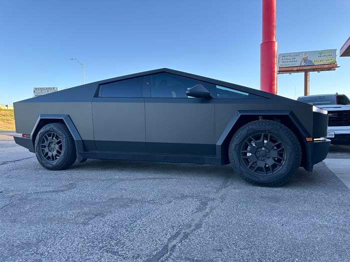 Matte black Tesla Cybertruck parked on asphalt.