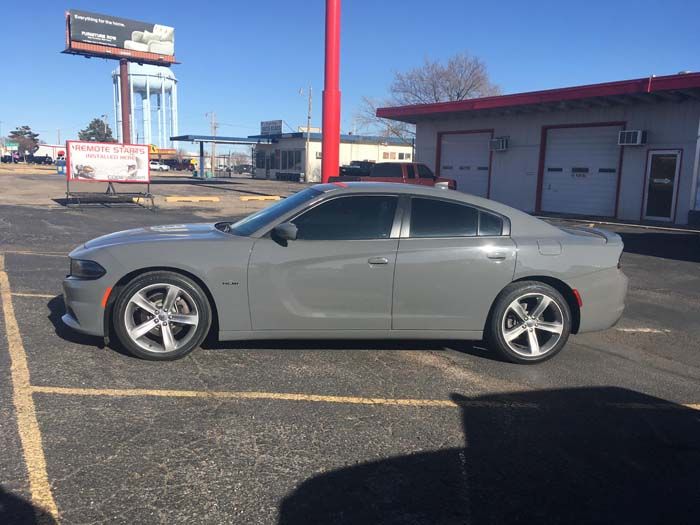 Gray Dodge Charger parked outside a building on a sunny day.