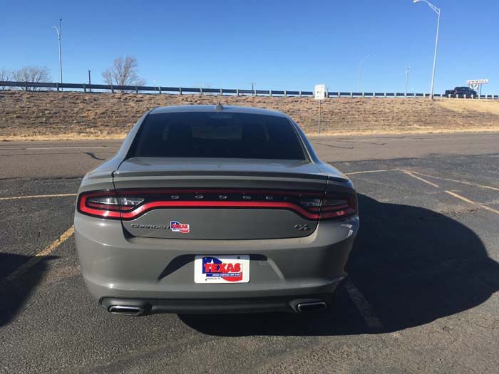 Gray Dodge Charger parked in a lot on a sunny day.