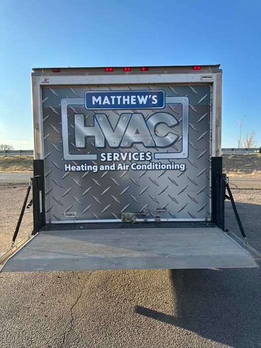 Rear of a trailer with Matthew's HVAC Services logo on a diamond plate background, open lift gate.