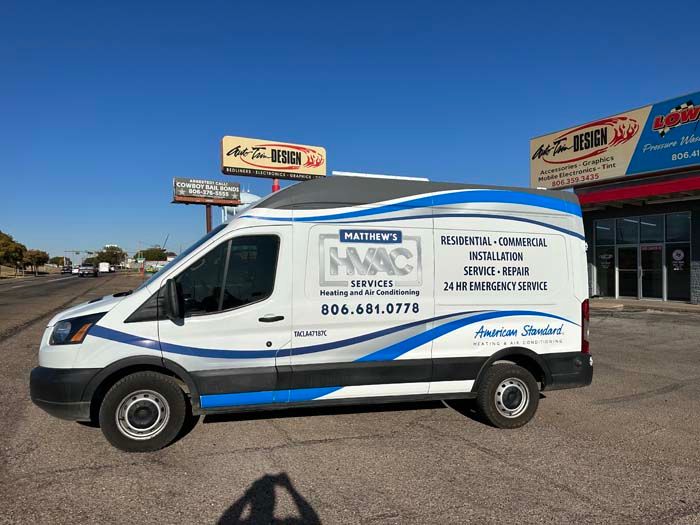 White HVAC service van with blue accents, parked on a street. 