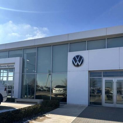 Volkswagen dealership exterior on a sunny day with the logo visible.