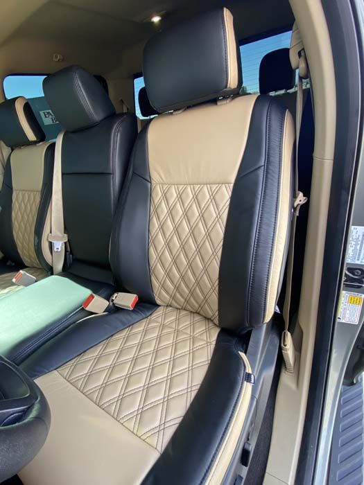 Black and tan leather car seat with diamond stitching, inside a vehicle.