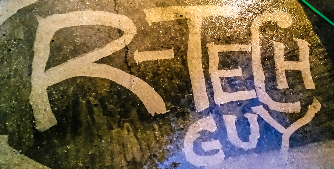Graffiti reading “R-TECH GUY” in white on a colorful painted wall