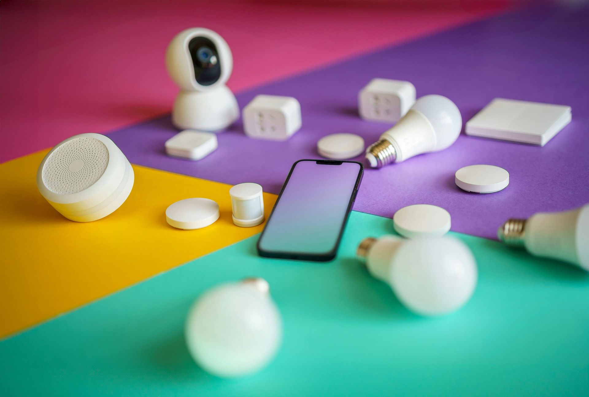 Smartphone surrounded by white smart-home devices on a colorful gradient background
