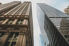 Looking up at two tall buildings in a city