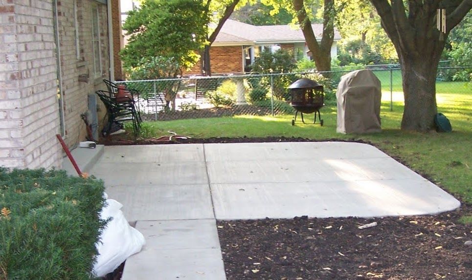 A brick house with a concrete patio in front of it