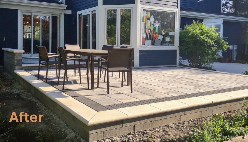 A patio with a table and chairs in front of a blue house.