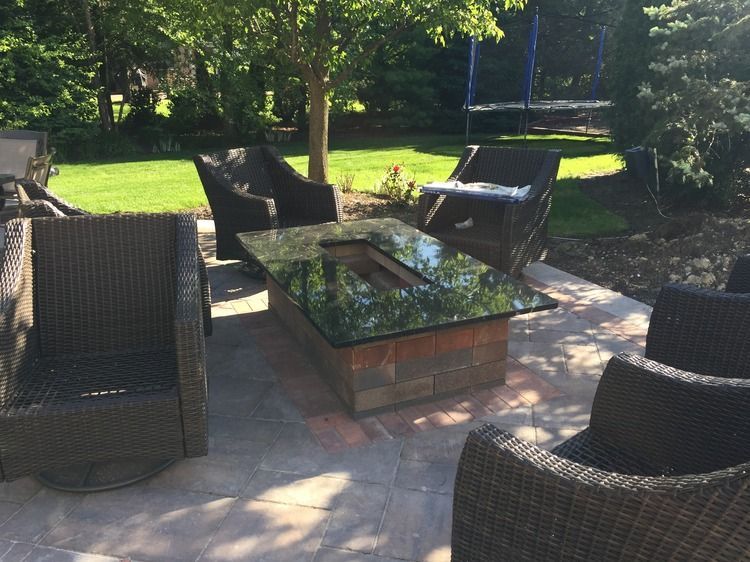 A patio with wicker furniture and a fire pit