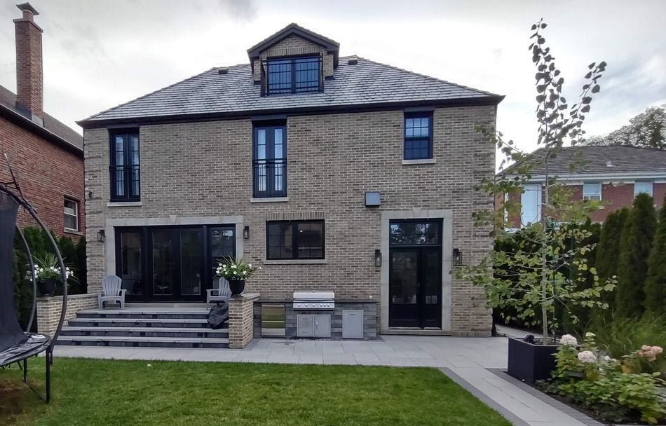 A large brick house with a large lawn in front of it.