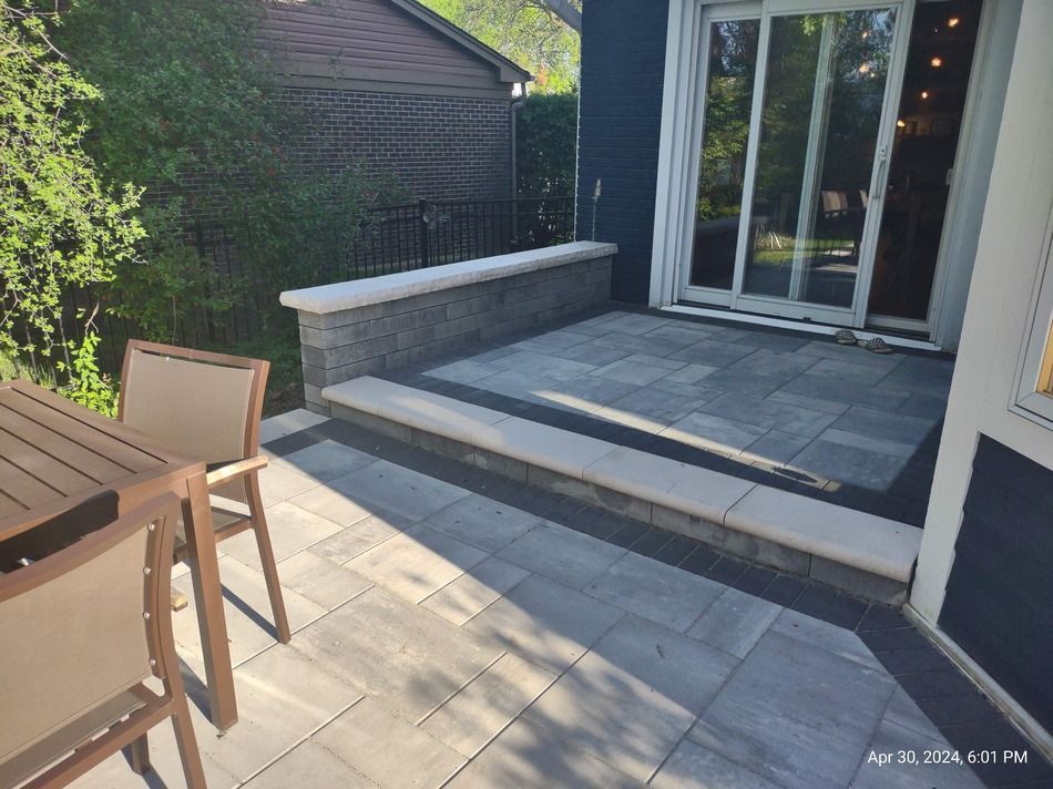 A patio with a table and chairs and a sliding glass door.