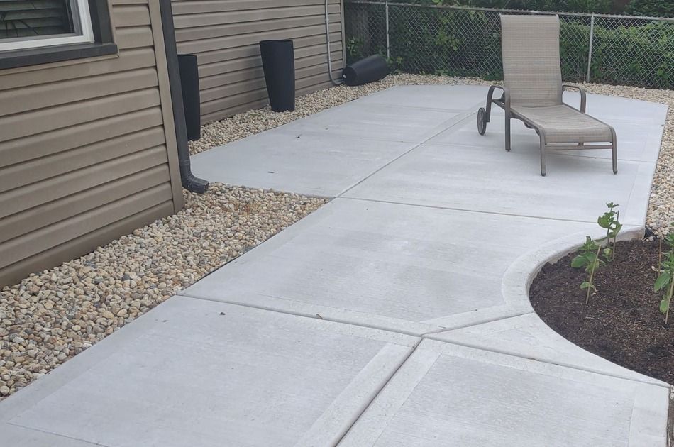 A concrete patio with a chair in the middle of it