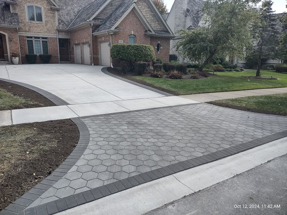 A brick house with a driveway and sidewalk in front of it.