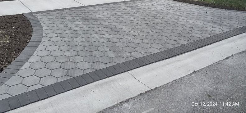 A picture of a brick driveway with a curb.