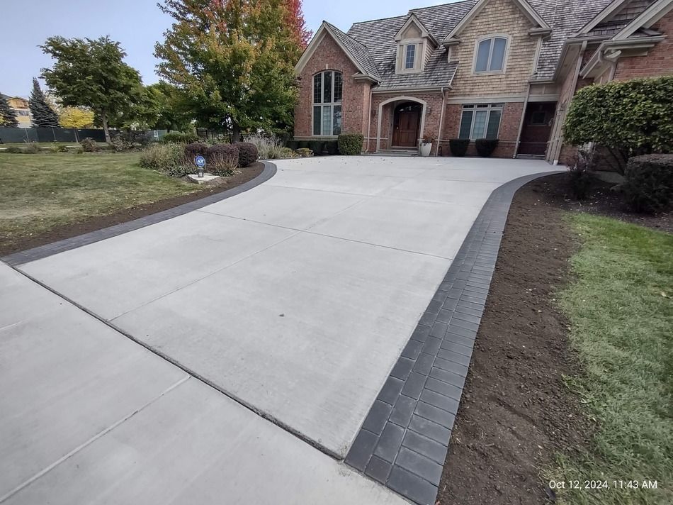 A large brick house with a concrete driveway in front of it.