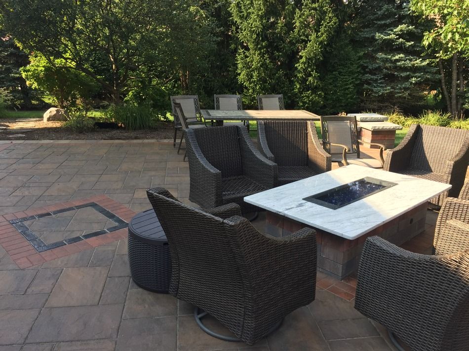 A patio with wicker furniture and a fire pit