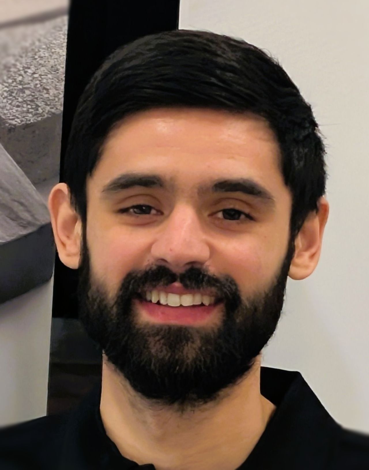 A man with a beard and mustache is smiling for the camera.