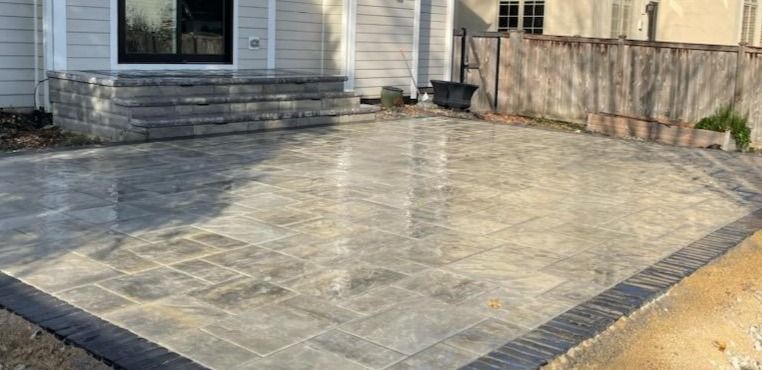 A patio is being built in front of a house.