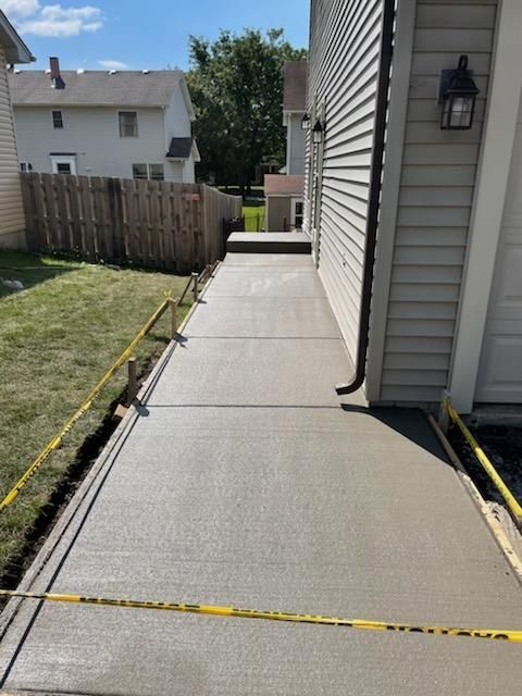 A concrete walkway is being built in front of a house.