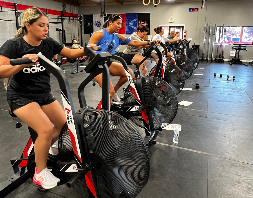 A group of women are riding exercise bikes in a gym.