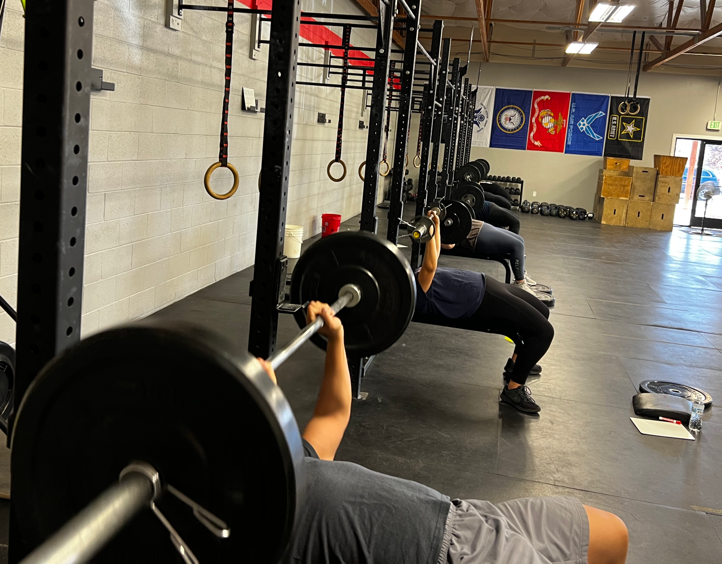 A man is lifting a barbell in a gym.