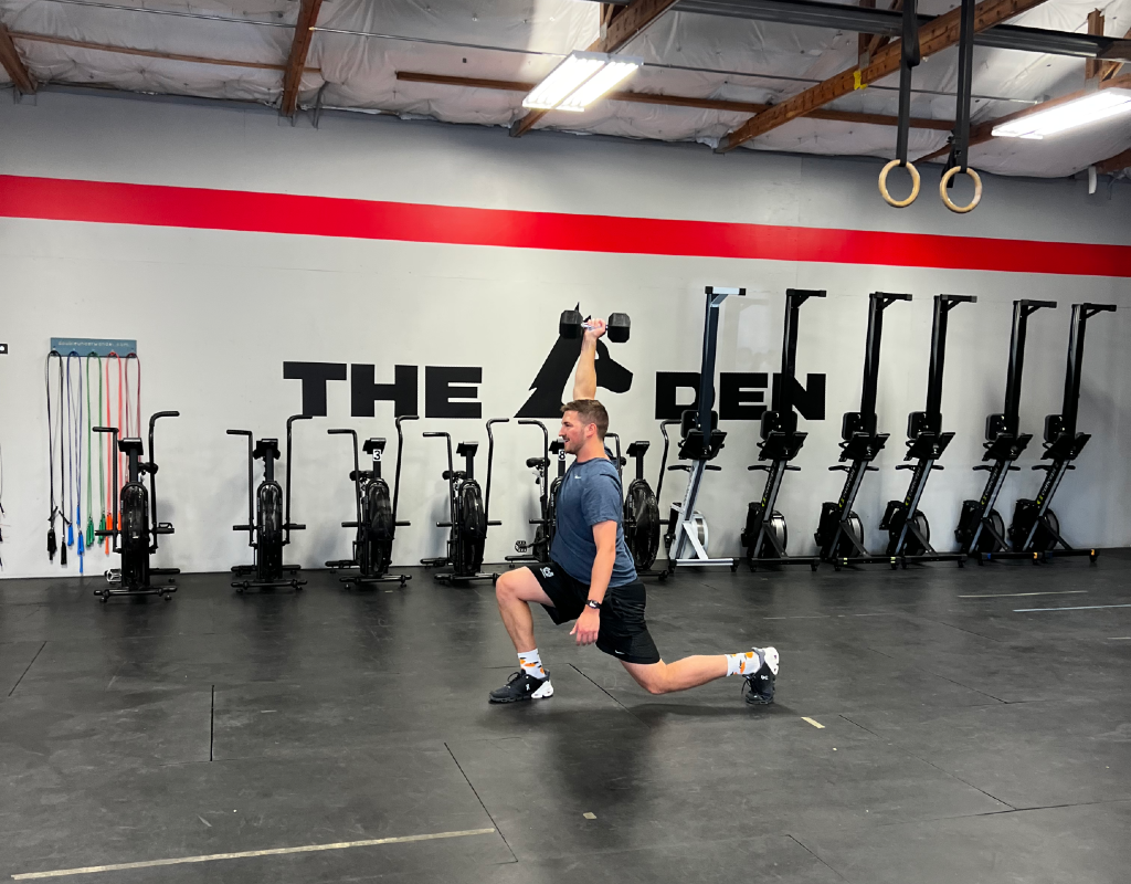 A man is doing a lunge in a gym.