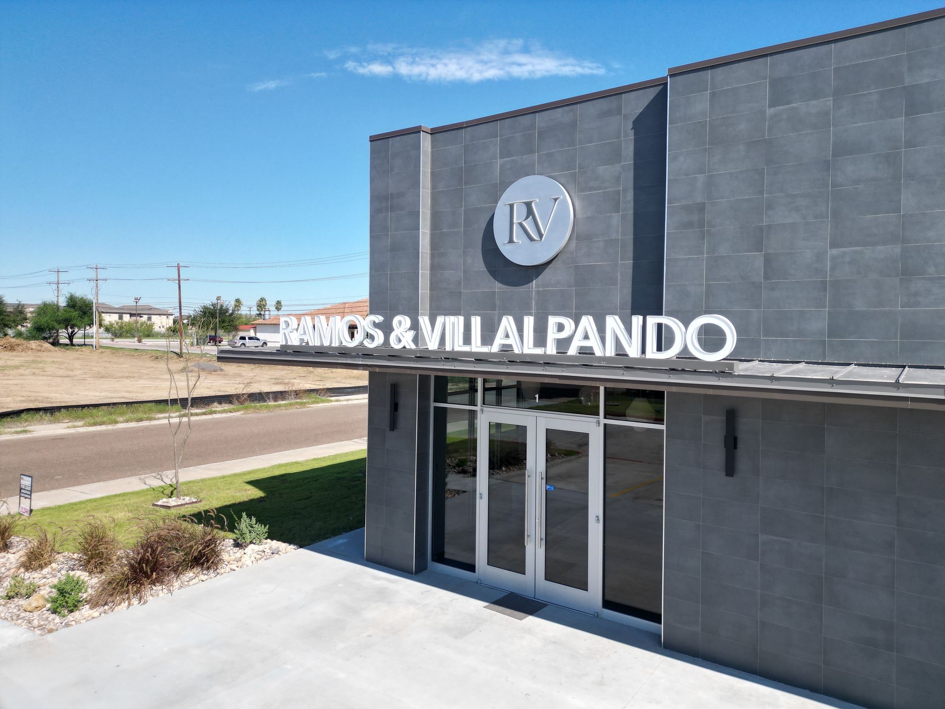 The exterior of the Ramos & Villalpando offices.  A portion of the street leading to the office is visible.
