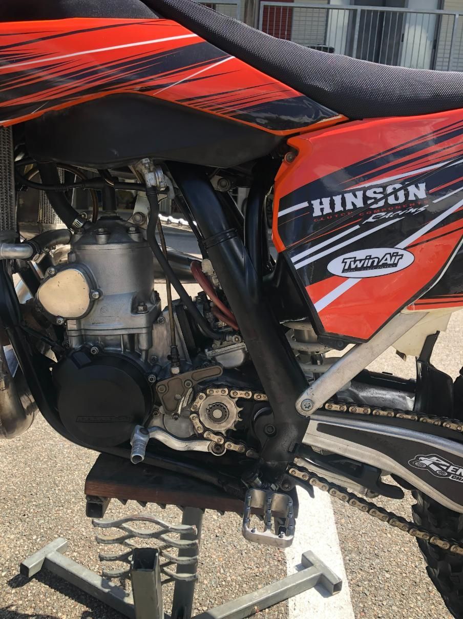 Orange and black dirt bike on a stand; close-up of engine, frame, and seat. — Bodes All Mechanical In Eden, NSW