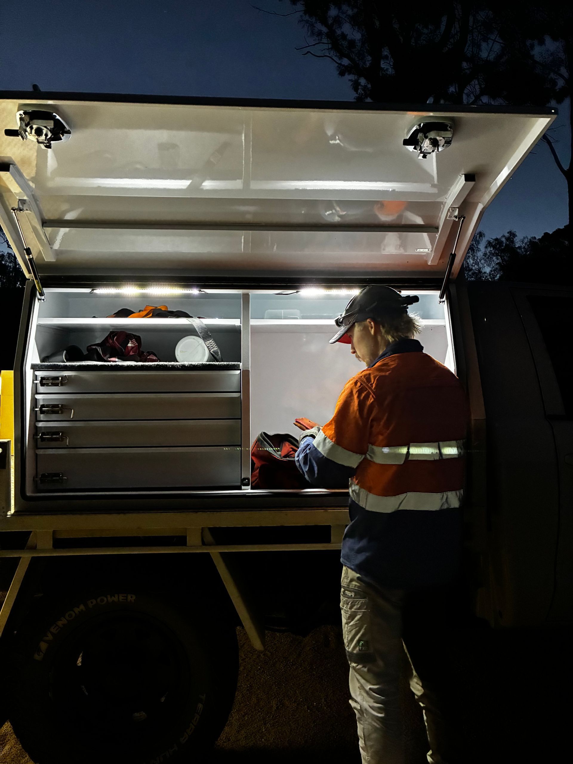 Worker in Reflective Gear at Night, Inside a Truck Bed Toolbox — Bodes All Mechanical In Tantawangalo, NSW