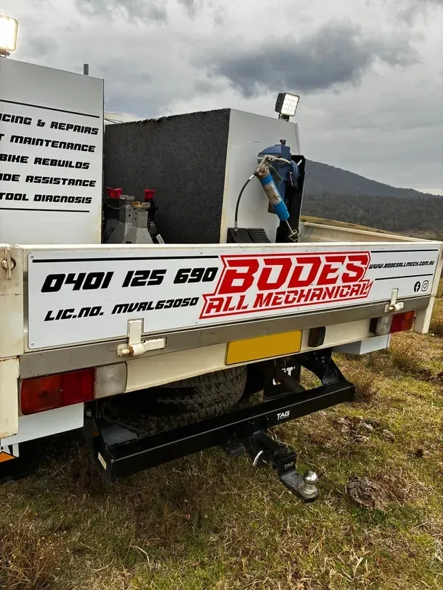Rear view of a white service truck with business signage,