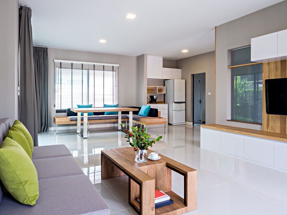 Modern living room with gray sofa, wooden table, and built-in entertainment unit.