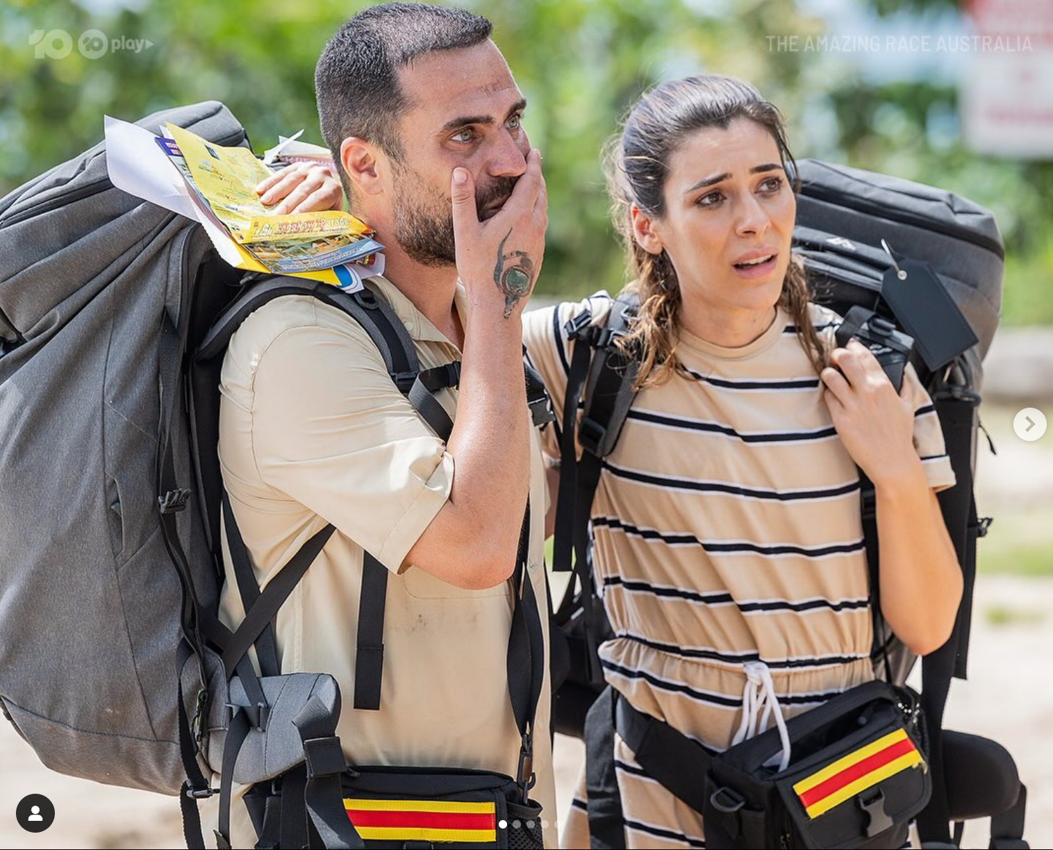 A man and a woman with backpacks are standing next to each other.