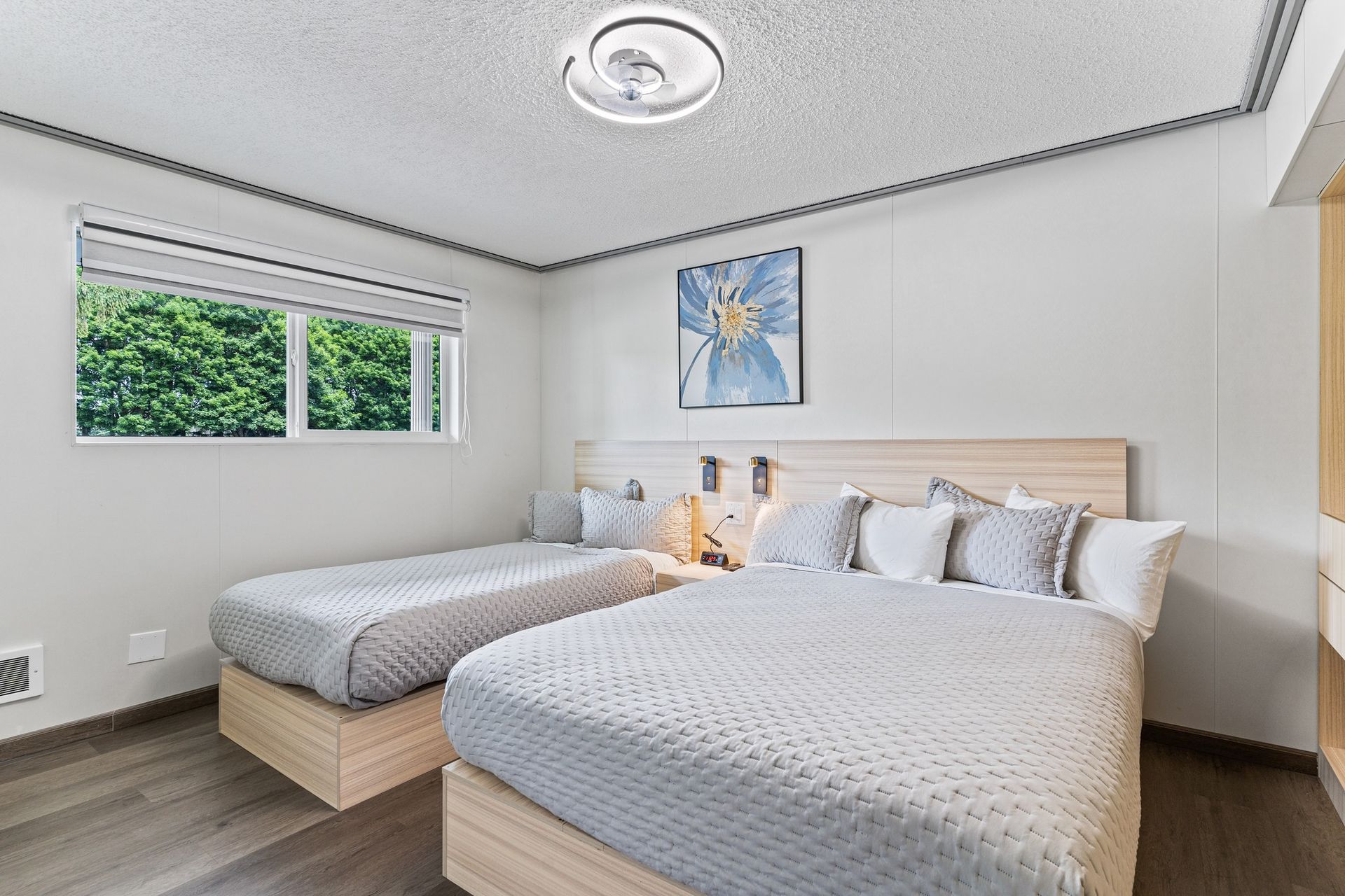 A hotel room with two beds and a window.