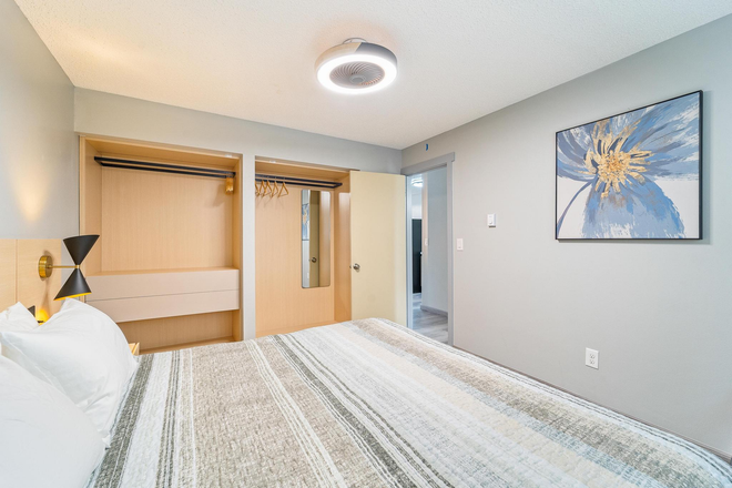 A bedroom with a bed and a painting on the wall.