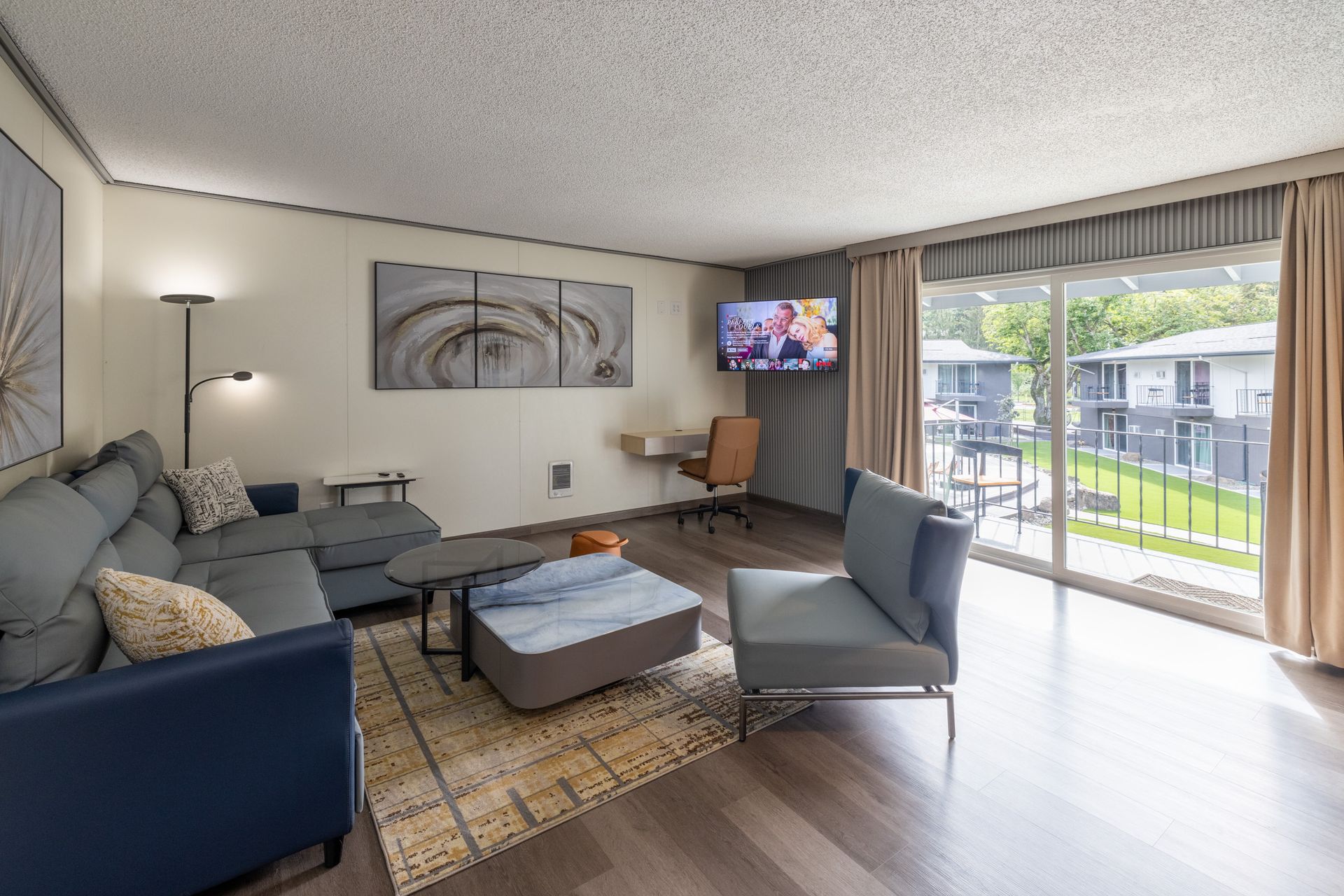 A living room with a couch , chair , coffee table and television.