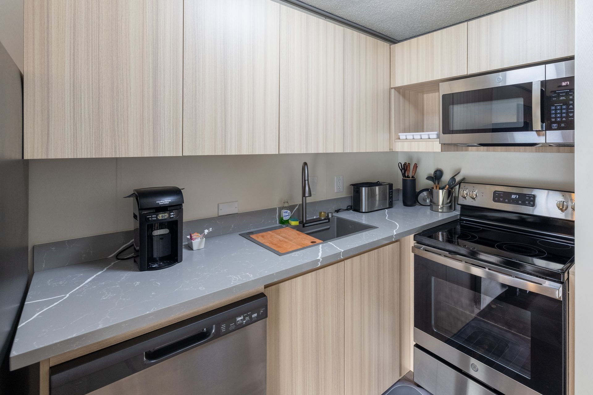 A kitchen with stainless steel appliances and wooden cabinets.