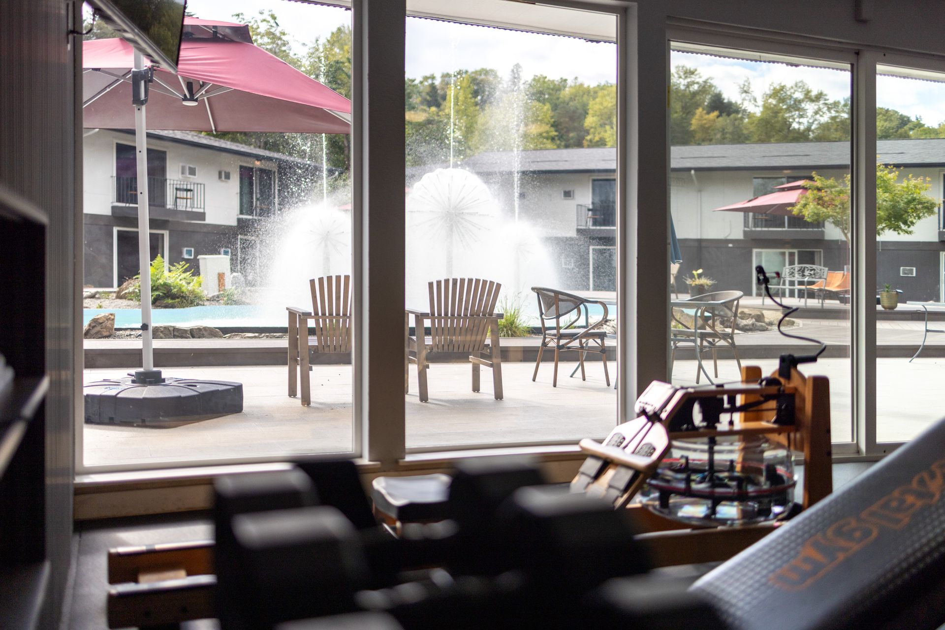 A gym with a view of a fountain and a pool.