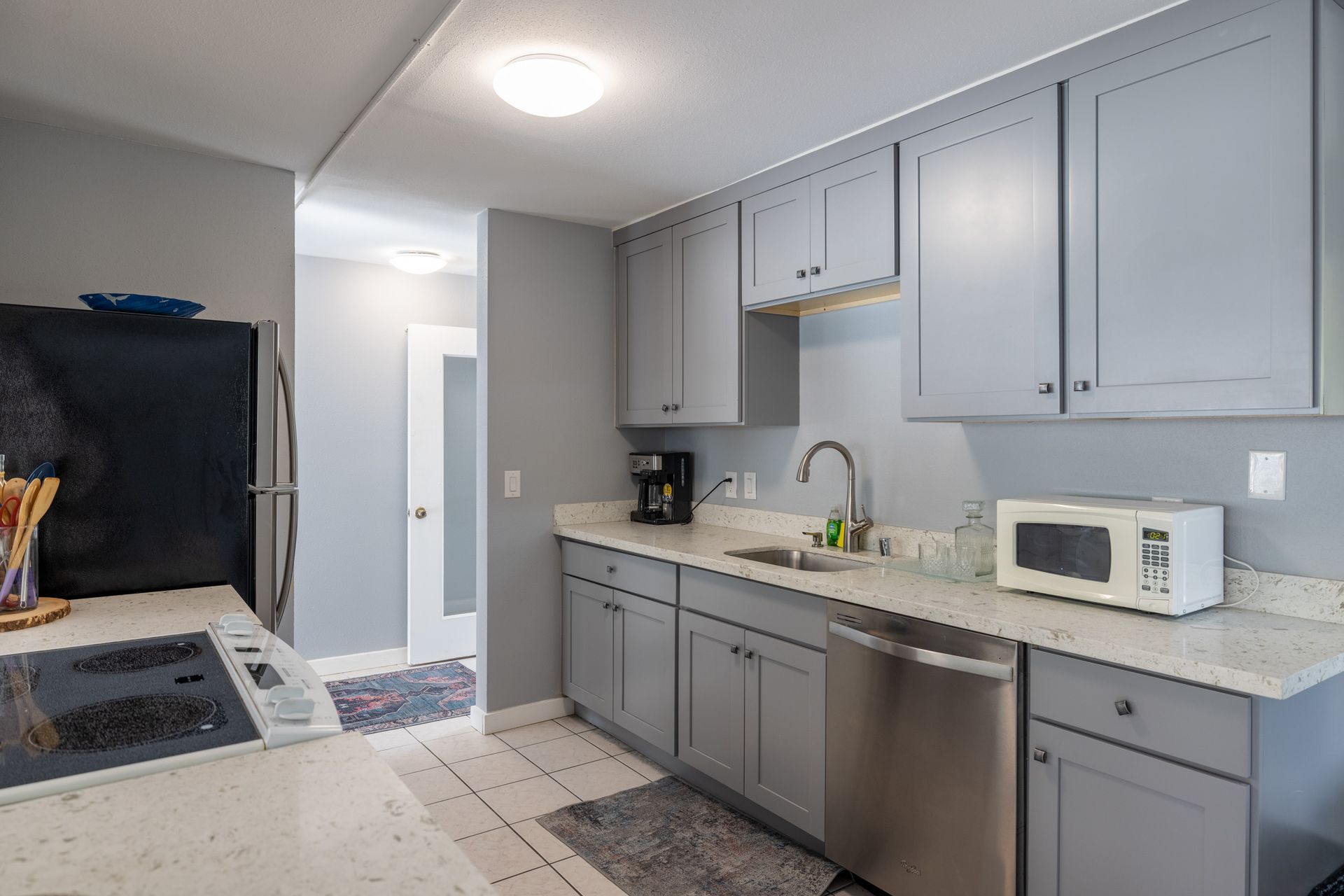A kitchen with gray cabinets and stainless steel appliances