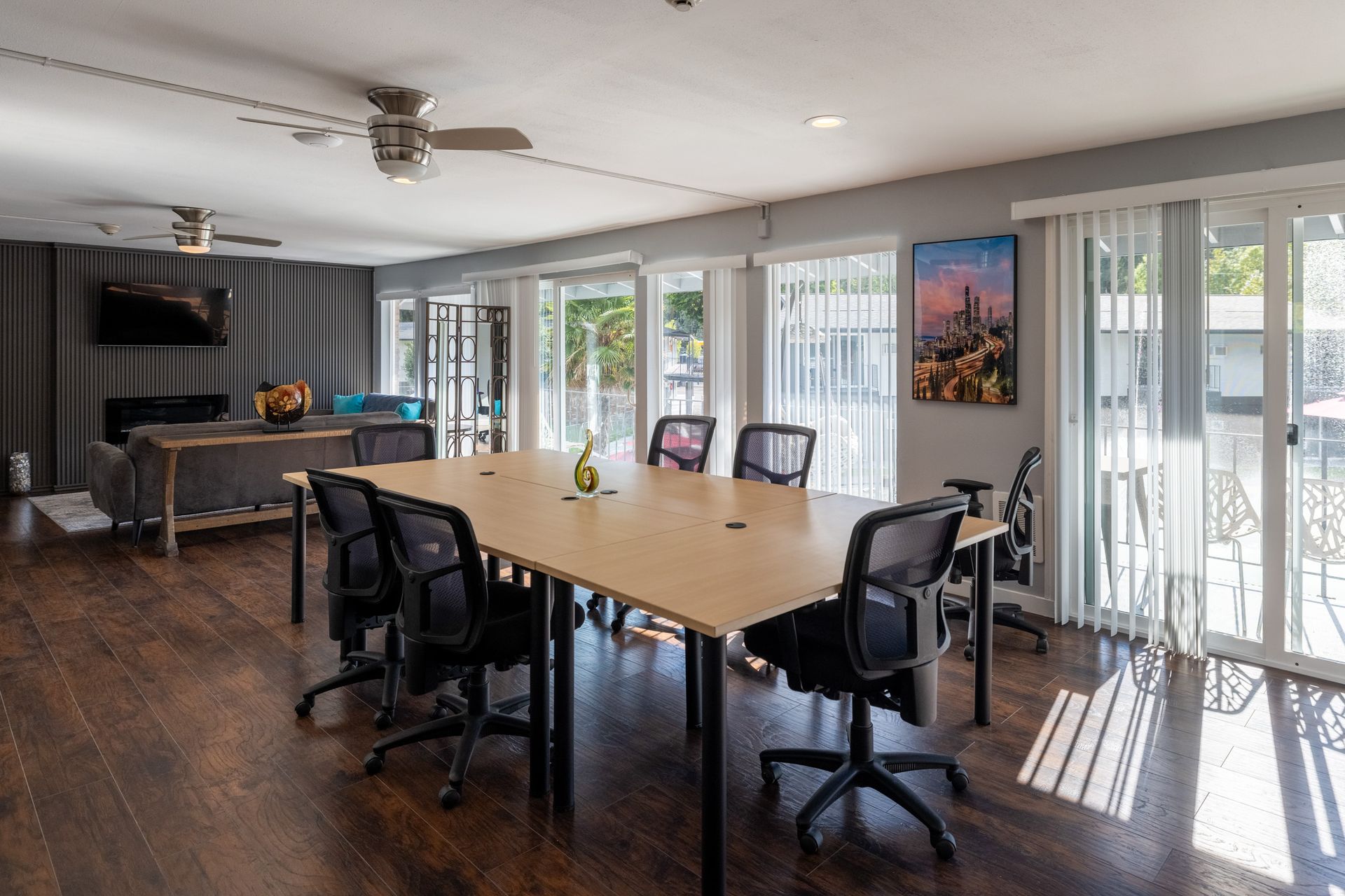A large room with a table and chairs and a ceiling fan.
