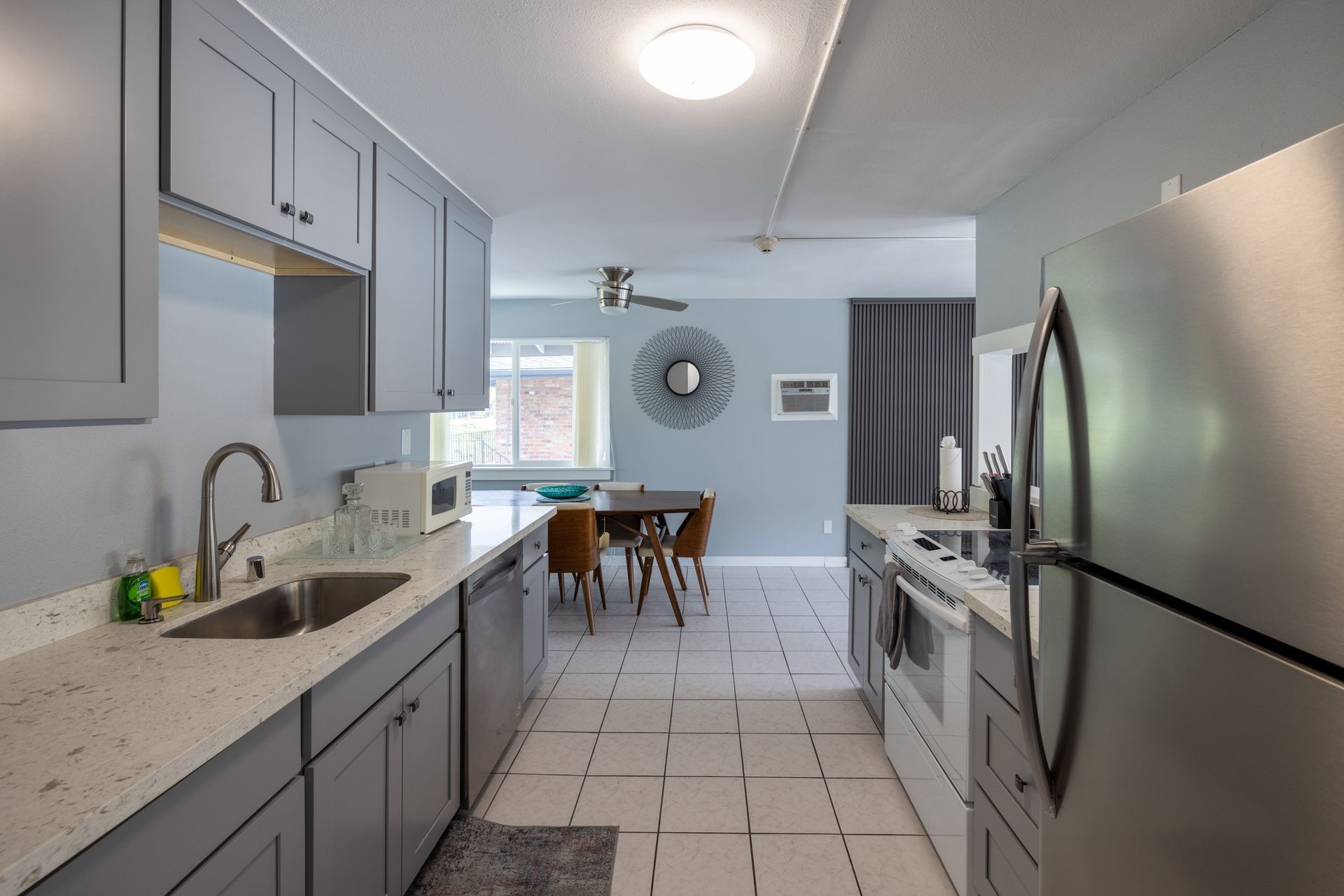 A kitchen with stainless steel appliances and gray cabinets