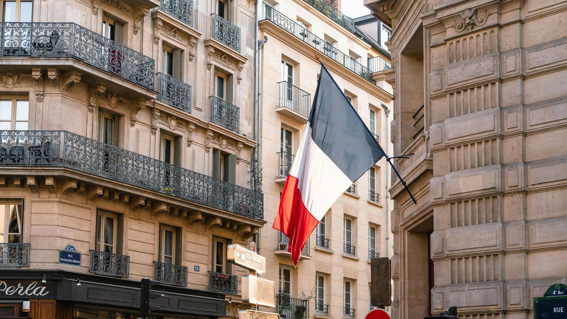 Picture of an Hausmanian Builinding in Paris with the french flag during a walking tour with a local