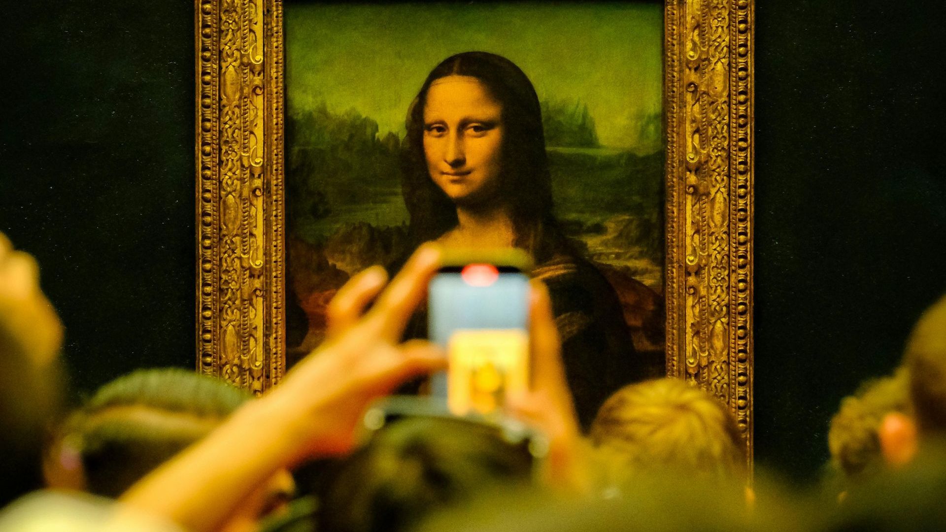 Mona Lisa inside the Louvre Museum getting pictured by tourists