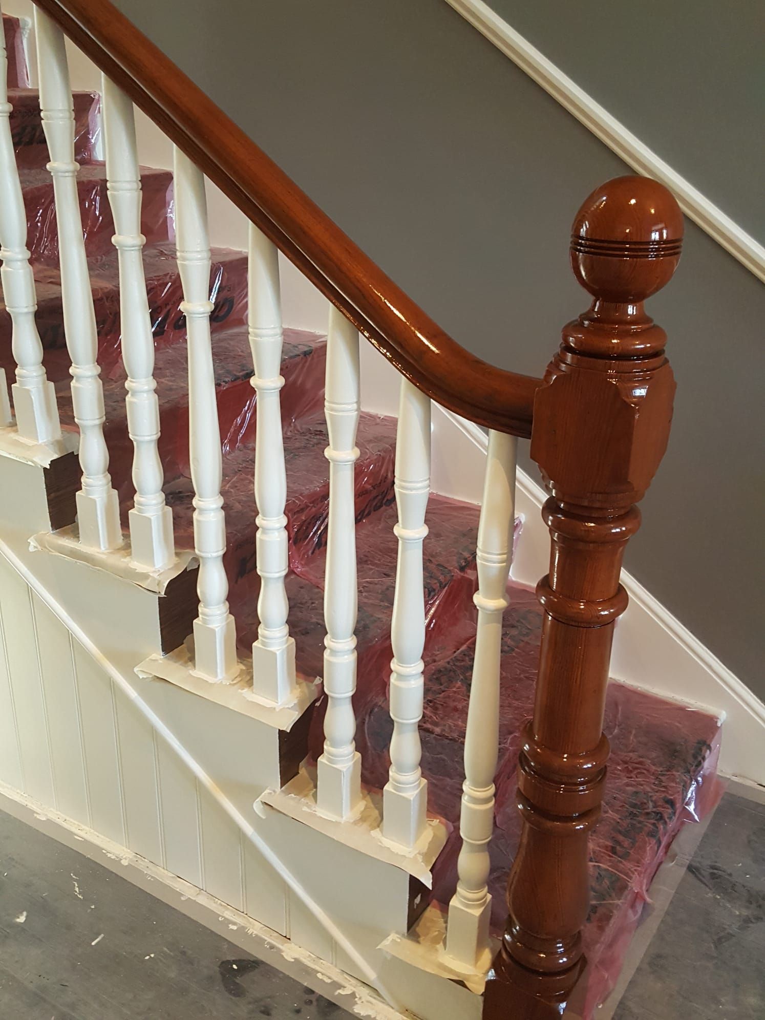 A staircase with a wooden railing and white steps